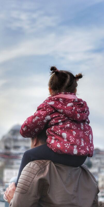 Father with child on shoulders.